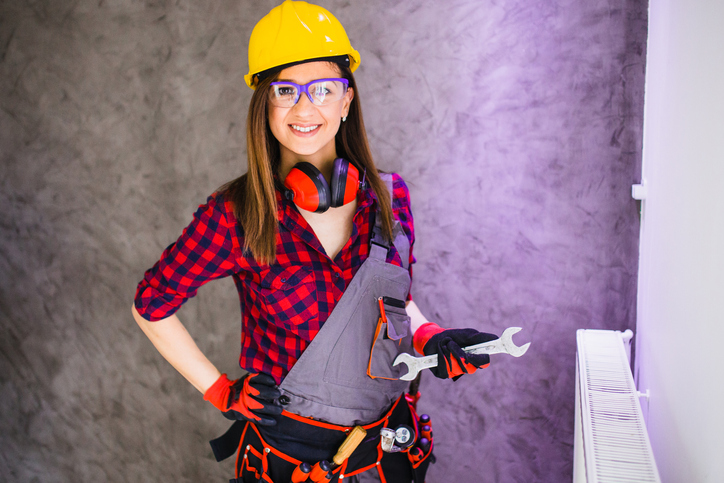 Lady wearing hard hat and work overalls